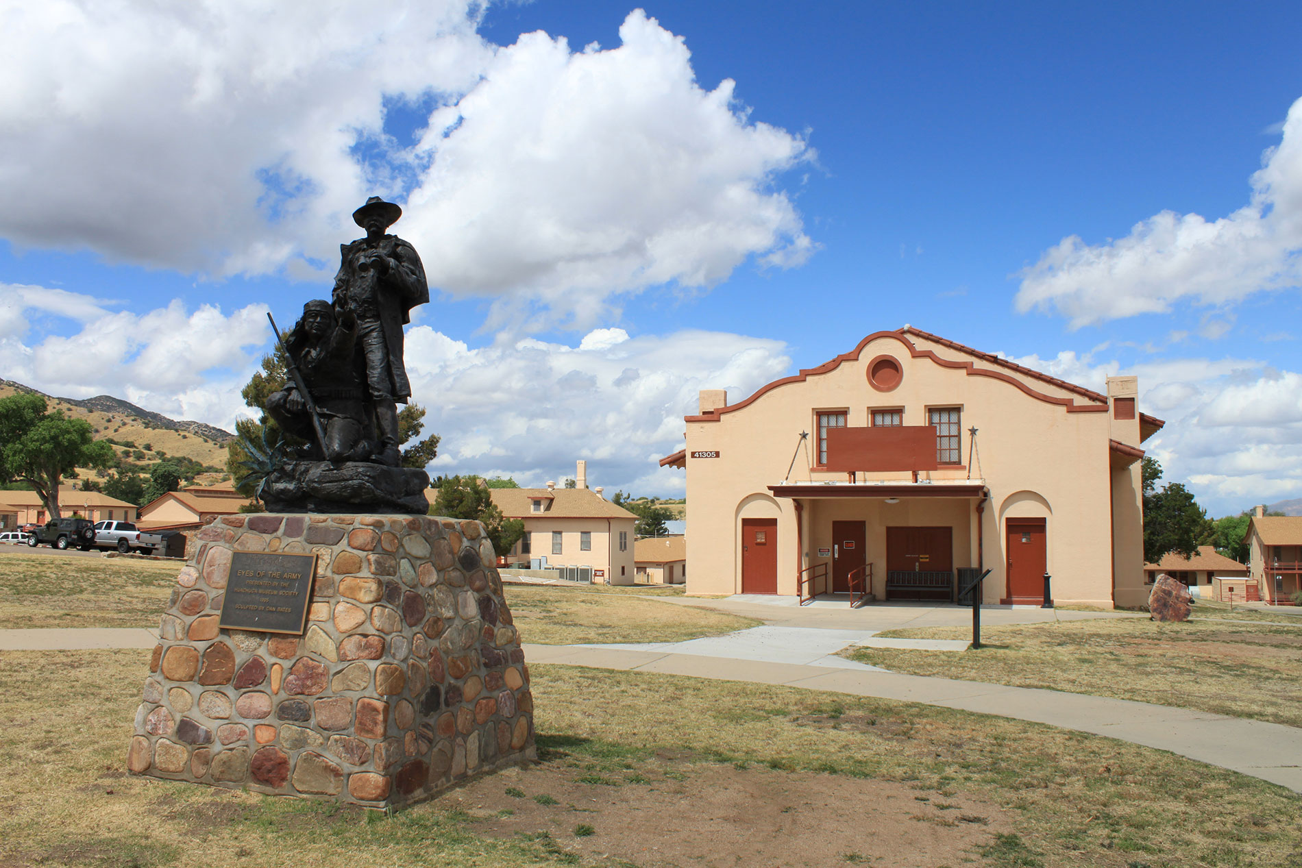 A statue of two people directly outside Fort Huachuca Museum on nice day.